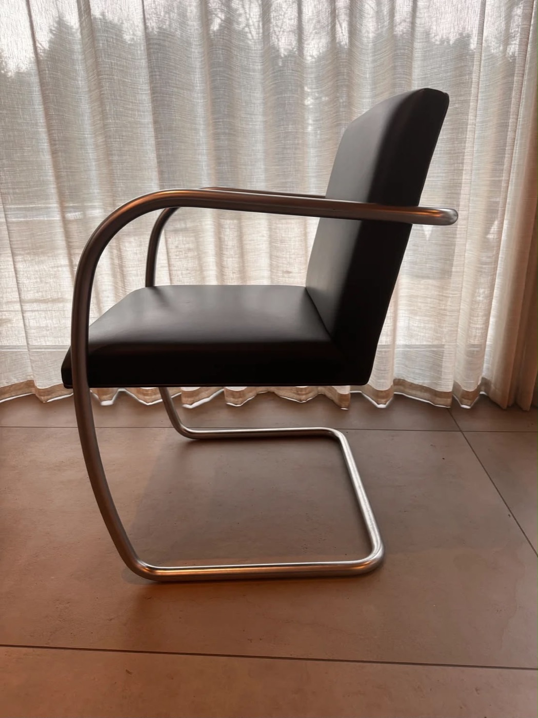 Knoll Brno Chair Black Tubular Hardware in black leather, side view photographed in situ