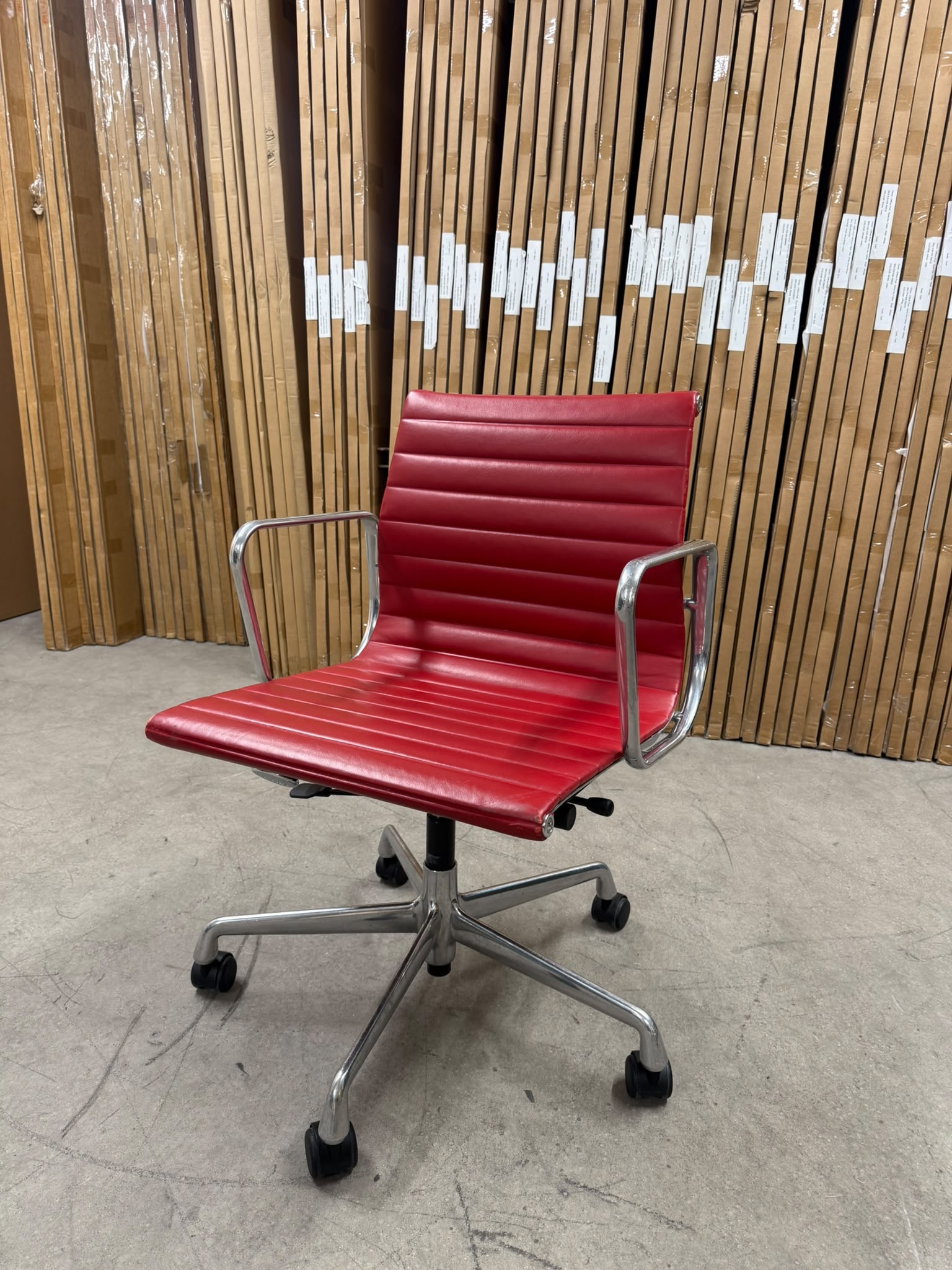 Vitra Eames Aluminium chair EA117 red leather front three-quarter view