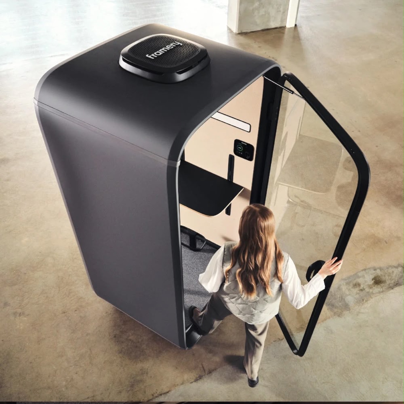 Framery One Essentials soundproof phone booth black seen from above with the door open as someone steps in